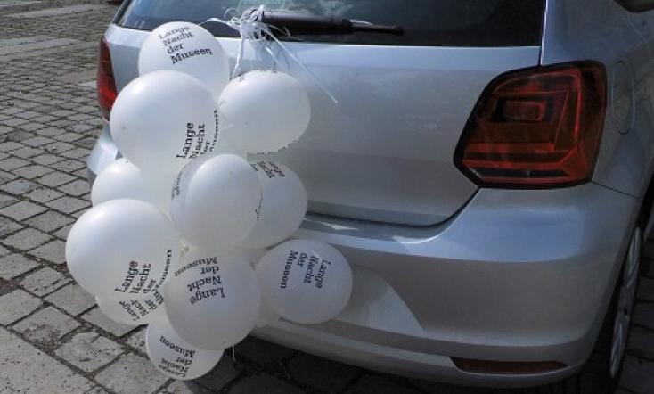 Weiße Luftballontraube an einem Auto