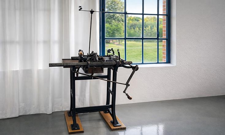 Maschine in einem hellen Raum mit Blick durch ein Fenster nach außen