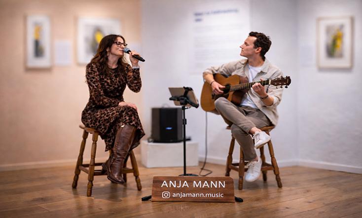 Musiker auf der Bühne in einem Museum mit Gitarre und Gesang