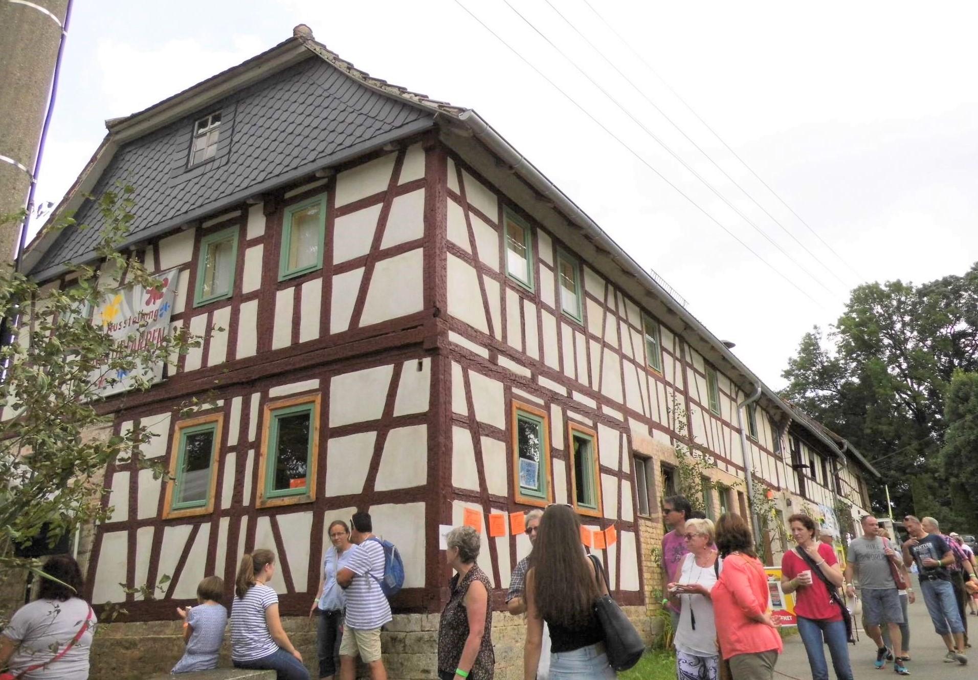 Haus der Farben Blick auf ein Fachwerkhaus mit davor stehenden Besuchern